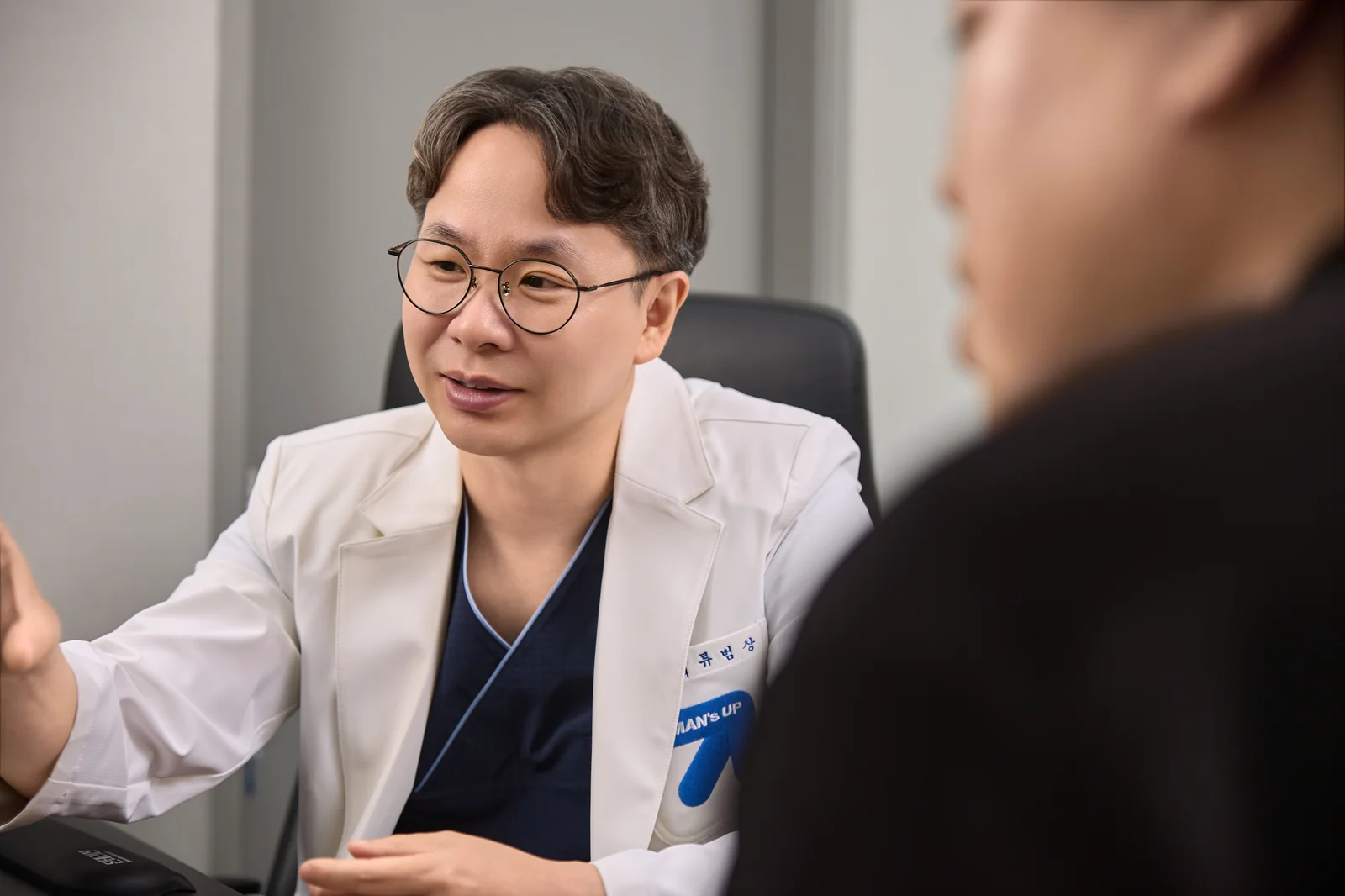 류범상 원장이 환자와 마주 앉아 치료 방법과 주의할 점을 설명하는 모습